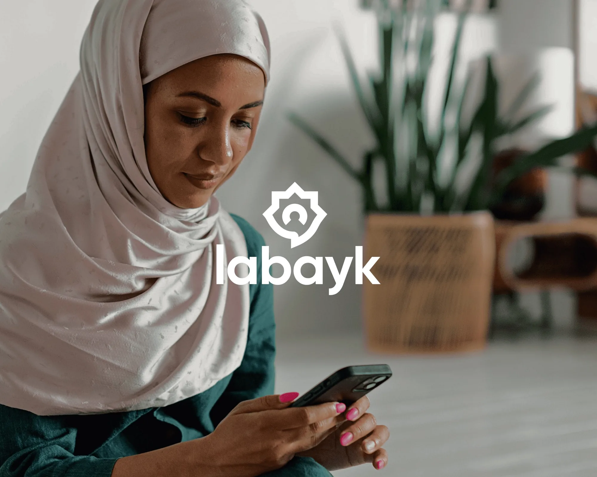 Labayk App — a woman holding a phone showing the labayk logo